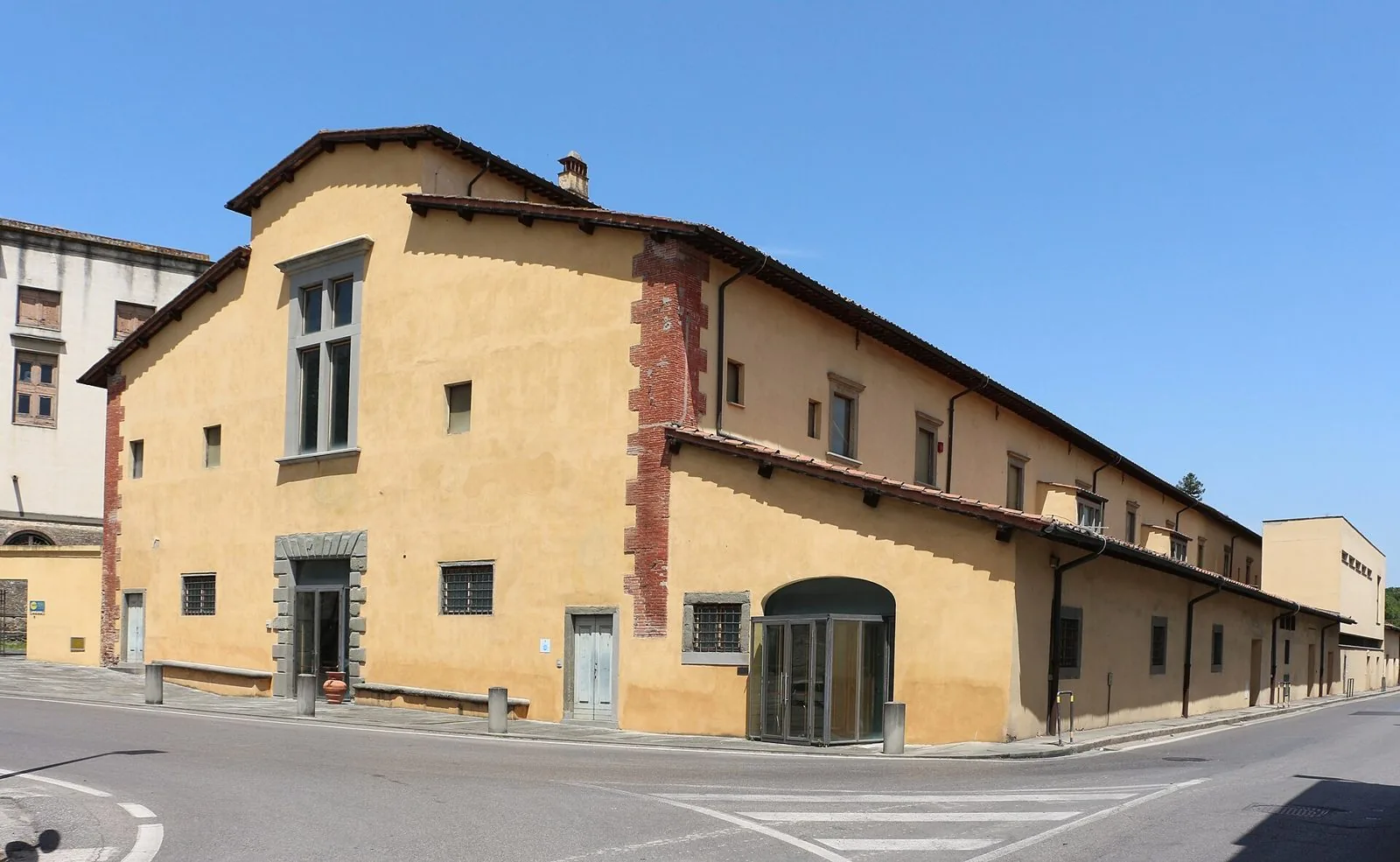 L'edificio delle Scuderie medicee di Poggio a Caiano, lungo corpo intonacato giallo con cantonali in mattoni, sotto un cielo azzurro